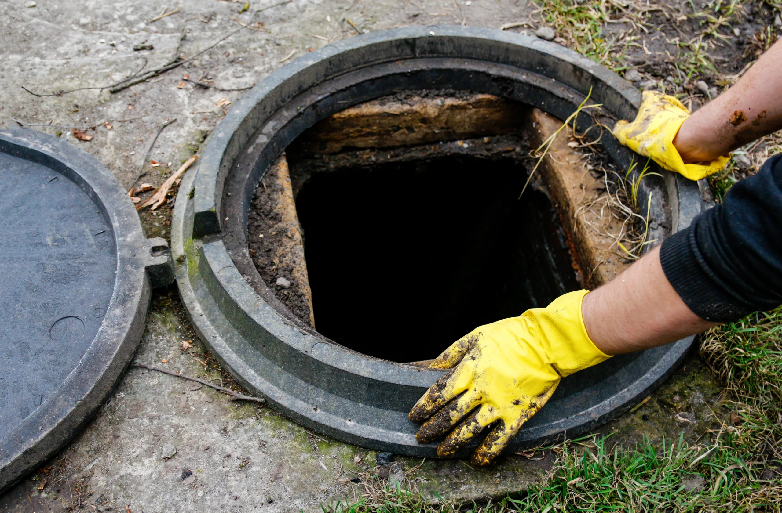 Worker accessing and cleaning a drainage structure